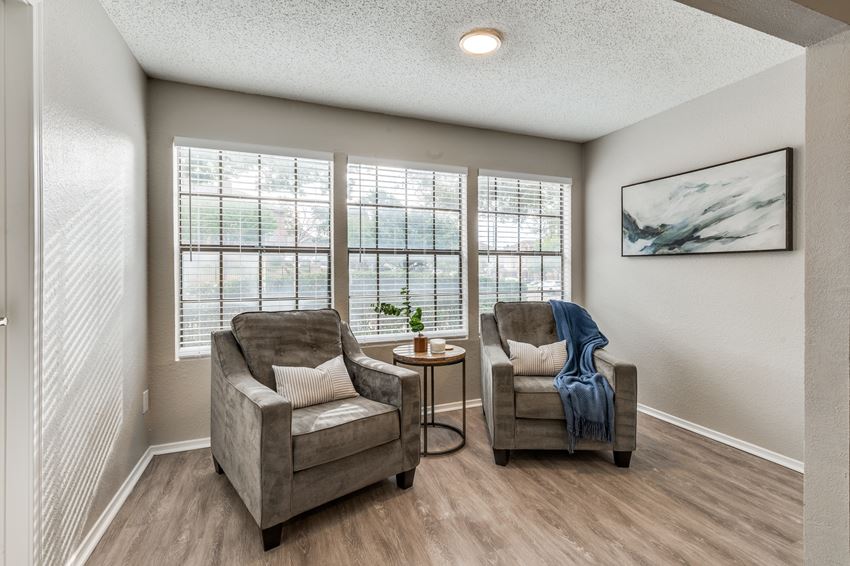 a living room with two chairs and a window